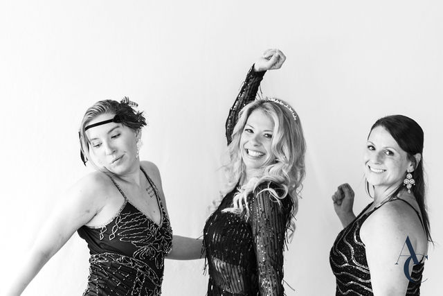 Guests in 1920s dress posing with arms raised