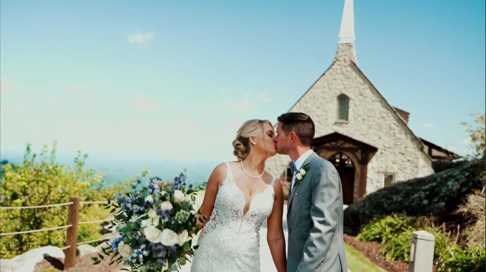 Couple kissing outside a mountain chapel