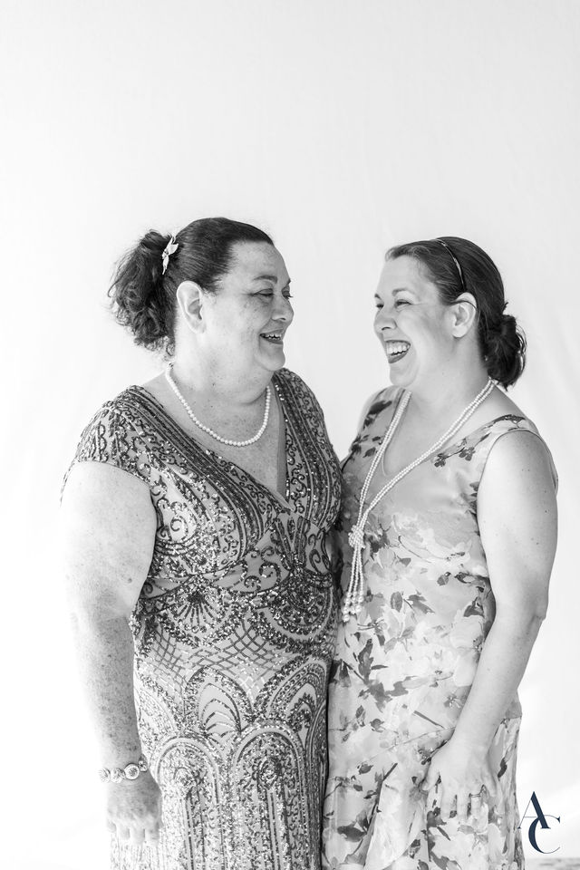 Two gala guests sharing a laugh in front of the backdrop