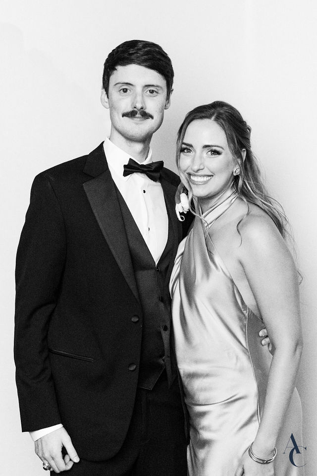 Groomsman and guest posing formally in black and white