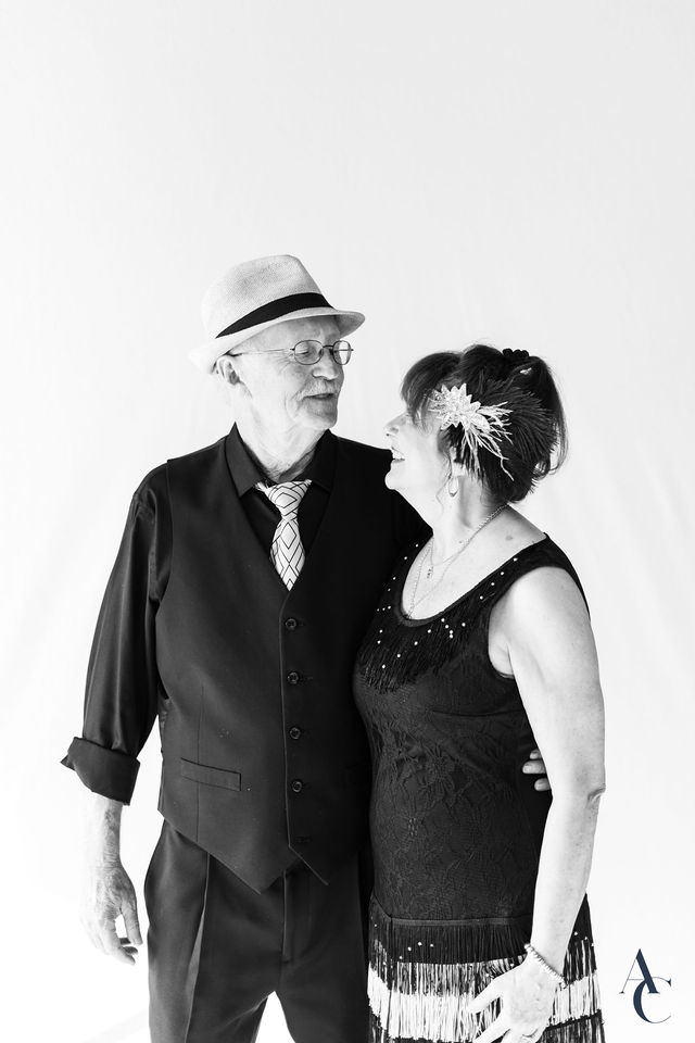 Couple in vintage attire posing for a black and white portrait