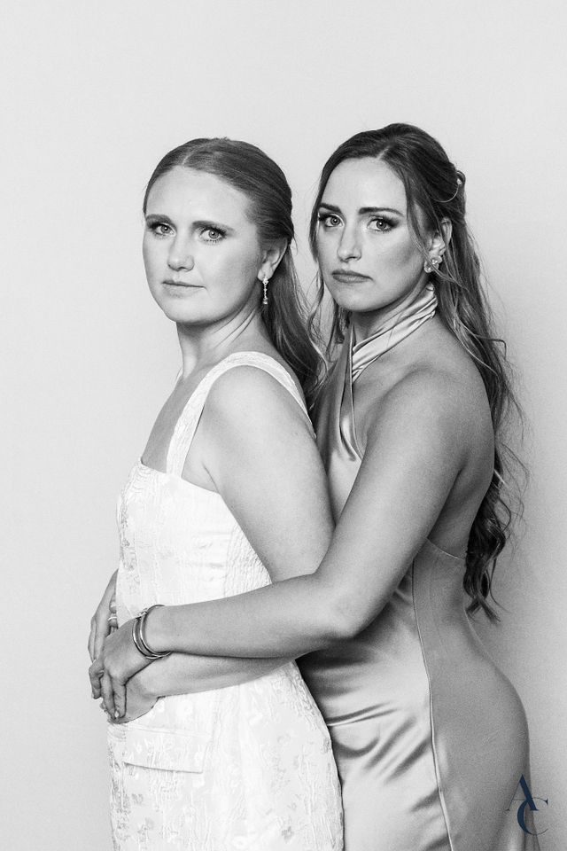 Bride and guest holding each other for a portrait